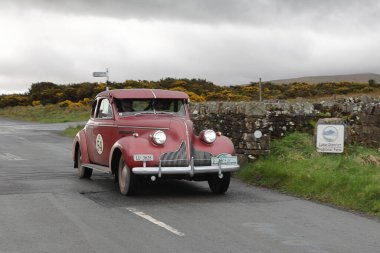 A 1939 Buick Century 66S leaves Caldbeck, Cumbria.  The car is taking part in the Flying Scotsman Rally, a free public-event. clipart