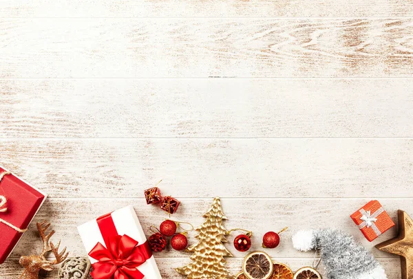 Karlı beyaz masa arkaplanında Noel hediyeleri ve süslemeleri olan kompozisyon
