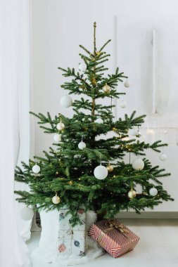 Boşboğaz ve paketlenmiş hediye kutularıyla dolu Noel Ağacı Karlı bir arkaplan ortamında sunar