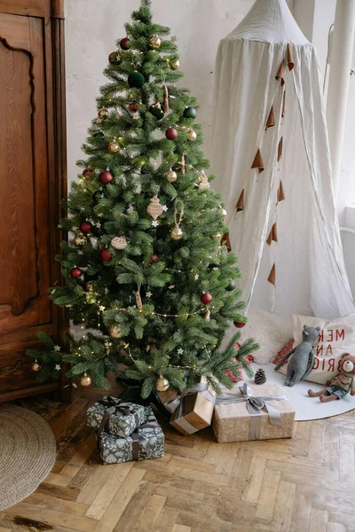 Süslü bir Noel ağacı. Kırmızı, beyaz, altın, altın ve paketlenmiş hediye kutuları.