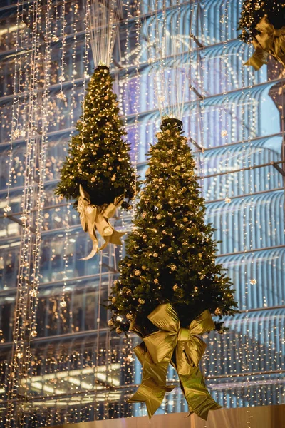 Binasında altın ampuller olan bir şehirde süslü Noel Ağaçları