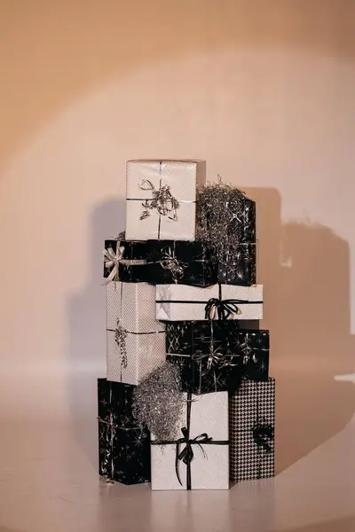 Tamamen dekore edilmiş ve paketlenmiş siyah beyaz Noel hediye kutuları spot ışıklarıyla
