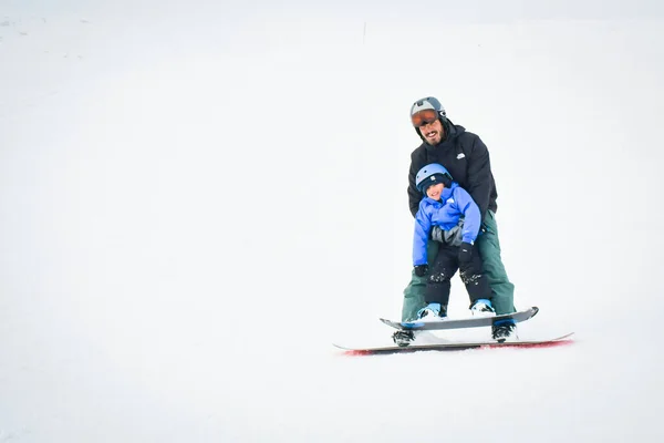 グドーリ ジョージア州 2022年3月25日 父はスノーボードに小さな男の子の子供を運ぶ楽しい笑顔が学習活動を楽しんでいます スキーリゾートのコンセプトで楽しい冬の家族の休日 — ストック写真