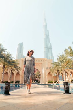 Dubai, BAE - 12 Ekim 2022: Kafkas kadın turist şehir merkezindeki sarayda yürüyüş yapıyor - Dubai 'deki ünlü fotoğraf mekanları avuç içi ve havuz tarafından
