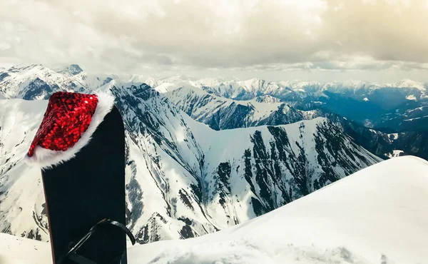 Zwarte Snowboard Met Kerstmuts Staan Sneeuw Prachtige Witte Kaukasus Bergen — Stockfoto