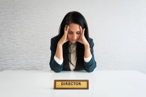 Caucasian young female director feel stressed at workplace, have problems working at empty desk. Frustrated ethnic woman worker anxious about company or business