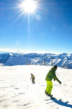 İki arkadaş, snowboardcular, kayak merkezindeki kayak merkezine geri dönüp birlikte dağlarda eğleniyorlar.