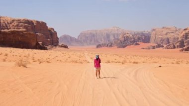 Kafkasyalı genç bir kadın cep telefonunu kontrol ediyor. Kayıp okuma haritası çölde aşırı sıcakta tek başına. Vadi rom çöl yürüyüşü ve yürüyüş rotaları