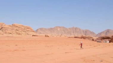 Wadi rum, Jordan - 5 Ekim 2022: Bayrak ve atlet yarışmacıları, Ultra X Jordan 'ın çok aşamalı ultra maratonuna meydan okumada aşırı sıcak çöl geçiş işaretleriyle hızlı yürüyorlar.