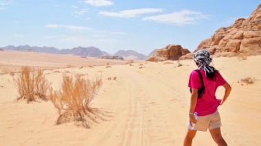 Turist yürüyüşü yapan kadın Wadi Rom 'da tatil yaparken vadi romu çöl yürüyüşü yapar. Ürdün 'de Popüler Wadi Rum Çölü