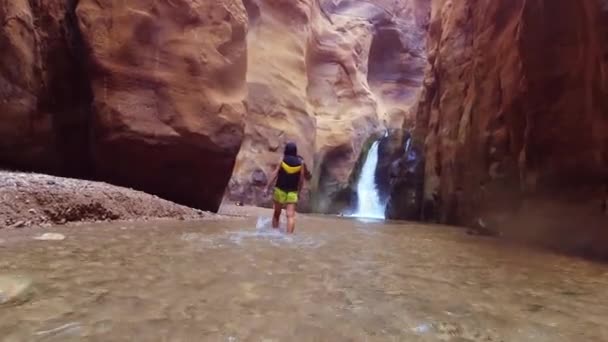 在著名的瓦迪穆吉布峡谷中 女性游客在水中漫步 呈现令人惊奇的金黄色 Wadi Mujib在约旦的旅行目的地 水下动作相机Pov — 图库视频影像