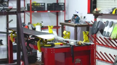 Kayak atölyesindeki aletleri yakınlaştır. Kayak ve snowboardların hazırlanması: Demir, fırça, kazıyıcı, kayganlaştırıcı - parafin, siyah ve kırmızı zemin üzerinde kayak. Yazı için boş bir boşluk.