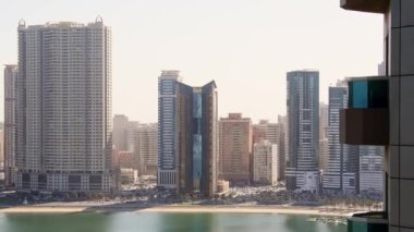 Sharjah bölgesinde balkonu ve marinası olan yüksek binalara panoramik pencere manzarası. Birleşik Arap Emirlikleri 'nde kiralık apartman manzarası ve gayrimenkul işi.