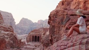 Petra antik kentinde, tarihi eser olan Ürdün 'ün ünlü seyahat merkezi ve yedi harikadan biri olan Petra' da oturan kadın gezgin turist. UNESCO Dünya Mirası