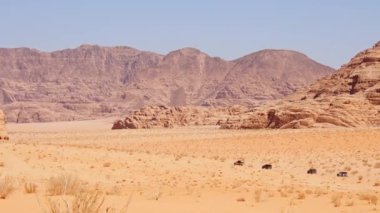 Turist yürüyüşü ve 4 WD araçlı Wadi rum çöl manzarası. Ürdün 'de organize safari turunda Valley Desert Kum Yolu' nda sürüyorlar.