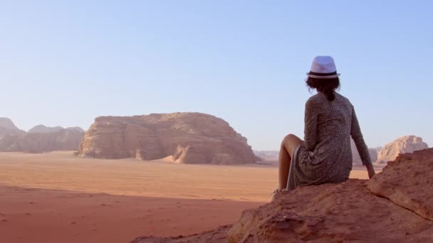 在Wadi Rum沙漠和Wadi Saabit山谷 穿着衣服的女游客站在悬崖上观看日落 约旦探索概念 — 图库视频影像