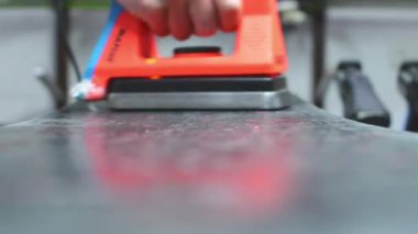 Kayak atölyesi çalışanı özel ağda demiriyle snowboard yapıyor. Kayak kayağı ağda servisi ve hazırlık