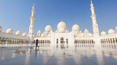 Abu dhabi, BAE - 3 Ekim 2022: Sheikh Zayed Camii 'nin etrafında turist yürüyüşü açık mavi gökyüzü gününde, Abu Dabi, Birleşik Arap Emirlikleri