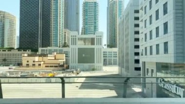 Dubai, BAE - 17 Ekim 2022: Güneşli gün ışığında kentsel cam ticari binalara metro yolcuları bakış açısı. İşe gidip gelmek ve Birleşik Arap Emirlikleri 'nde seyahatleri keşfetmek