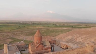 Aerial zoom out view historical landmark in Armenia - Khor Virap monastery with Ararat mountain peak background at sunrise