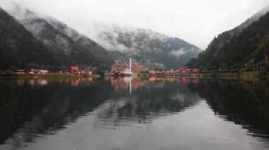 Fly over backwards reveal beautiful lake in Uzungol misty mountains village, Trabzon, Turkey