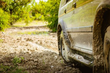 Manzarayı kapat. Çamurda dönen 4wd çekişli tekerlekler. Dışarıdaki macera turuna sıkışıp kalmış.