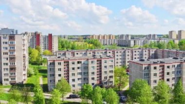 Litvanya 'nın Siauliai şehrinin güney kesiminde yaz mevsimi hızlandırılmış hava manzarasını yakınlaştır. Güneşli bir günde yeşil doğası ve bahçeleri arabalarla dolu eski Sovyet sendika binaları..