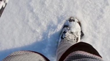 Point of view snowboarder dressed in a full protective gear for extreme freeride snowboarding posing with a snowboard walking. Isolated on gray white snow background.