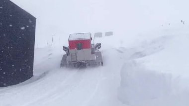 Kayakçıları götürmek için kulübesi olan kar arabası. Kayakçılar, uzak Kafkasya dağlarında tepeden aşağı bedavadan iniyorlar. Ratrak içeri.