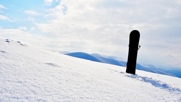 Μαύρη Snowboard Στο Χιόνι Όμορφα Βουνά Και Φρέσκα Σωματίδια Χιονιού — Αρχείο Βίντεο