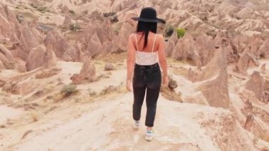 Caucasian Woman tourist enjoy freedom and travel holidays outdoors walk don among fairy chimneys in devrent valley , Cappadocia