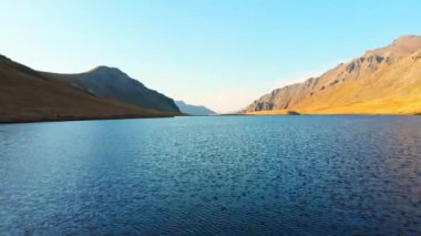 Aerial close up view over alpine lake in tranquil countryside in caucasus mountains