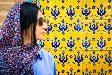 Kashan, Iran - 27th may, 2022: tourist stand pose for social media photo in public by wall with ornaments in traditional persian Fin garden Kashan, Iran