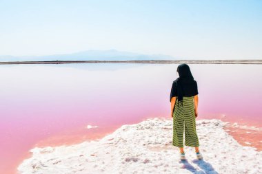 Maharlu pembe tuz gölü kıyısında beyaz kadın turist duruyor. İran 'ın Şiraz' a seyahat hedefi