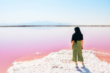 Caucasian woman tourist stand on Maharlu pink salt lake shore. Travel destination Iran in Shiraz clipart