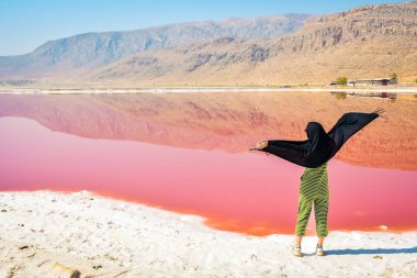Maharlu pembe tuz gölü kıyısında beyaz kadın turist duruyor. İran 'ın Şiraz' a seyahat hedefi