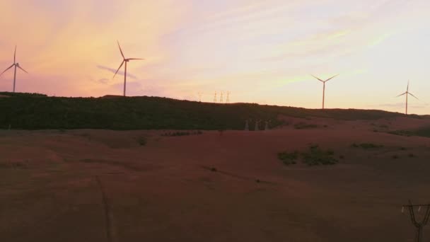 空中风力涡轮机在野外与明亮的橙色日落天空风力公园慢动作无人机转弯 风车的轮廓 夏天的镜头照明弹 替代能源概念 — 图库视频影像