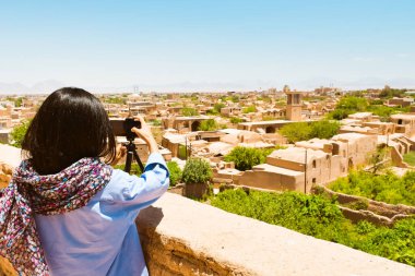 Tourist woman walk in ancient Narin Qal'eh (Qaleh) clay castle in the centre of Meybod near Yazd in Iran is one of the best preserved mud-brick fortresses