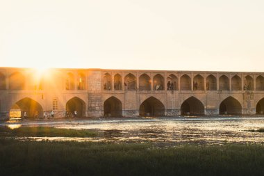 İsfahan, İran - Mayıs 2022: İnsanlar SioSe Pol çevresinde, Esfahan 'ın en eski ve Zayandeh Nehri üzerindeki en uzun köprülerden biri olan 33 kemerli köprü etrafında üşüşür ve sosyalleşir.
