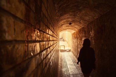 Yazd, Iran - 19th june, 2022: Woman in passage.Motorcycle stand by house in Yazd old town. Street photography and muslim lifestyle. Alleys and architecture. Transportation vehicle