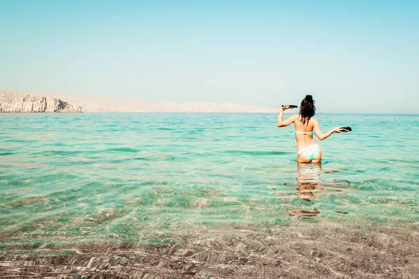 Молода Безтурботна Кавказька Жінка Туристка Танцює Пляжі Бірюзовій Воді Тримаючи — стокове фото