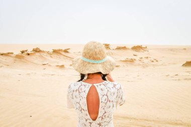 Kadın turist Fosil Dunes Structures 'ın fotoğrafını çekmek için bankta oturuyor. Abu Dabi, BAE. Kapitallerin dışında ünlü seyahat yerleri!