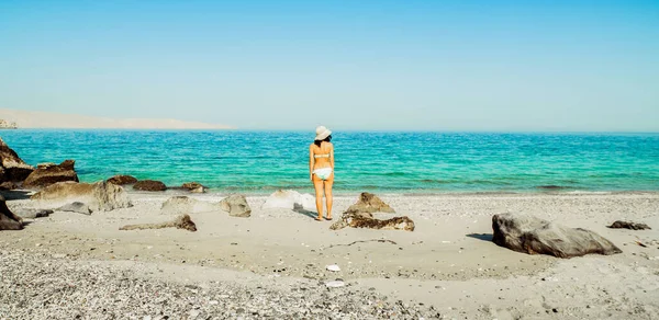 Panorama 'lı bikinili kadın İran Körfezi Mirellas Adası' nda tatilde tek başına beyaz kumlu sahilde duruyor. Musandam. Umman.