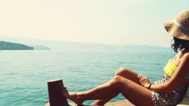 白种人女人放松地躺在游轮甲板上度假 享受着阳光灿烂的波斯海湾美景和岩石山崖 阿曼度假目的地 米雷拉群岛之旅 Musandam — 图库视频影像