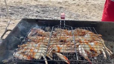 Yeni yengeçler, Umman 'daki plaj panoramasını kullanarak barbeküde pişiyorlar. Gurman yemek hazırlığı