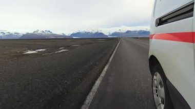 Camper van pov 'un lastik tekerleği manzaralı İzlanda güney çevre yolu 1' de gerçek zamanlı olarak döner. İzlanda 'ya yolculuk. Tatiller ve karavan kiralama gezi konsepti