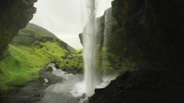 İzlanda 'daki ünlü seyahat merkezi Kvernufoss şelalesinin yanındaki kadın ziyaretçi standı. Bahar mevsiminde ünlü bir tatil beldesi. Turistik yerleri keşfetmek doğal harikalar yaratır.