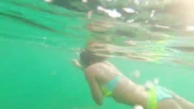 Mercan resif havuzunda balıkçılık okuluyla birlikte maske takan bir kız. Seyahat yaşam tarzı, su sporları açık hava macerası yaz tatillerinde yüzme dersleri.