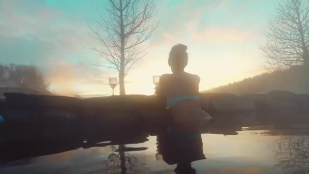 在冰岛著名的秘密泻湖里 美丽的高加索女性游客享受夕阳西下的美酒 — 图库视频影像