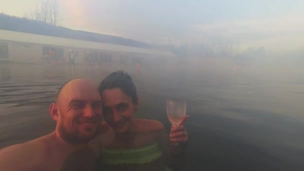 白种人夫妇在冰岛的温泉地热温泉里自拍 浪漫的放松在热水池享受沐浴放松在秘密的泻湖 冰岛旅游胜地 日落时分 — 图库视频影像